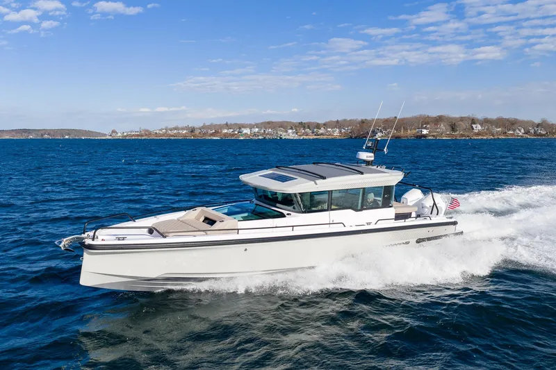 The Image of 2024 Axopar 37 XC Cross Cabin cruising on open water under a clear sky. - 0