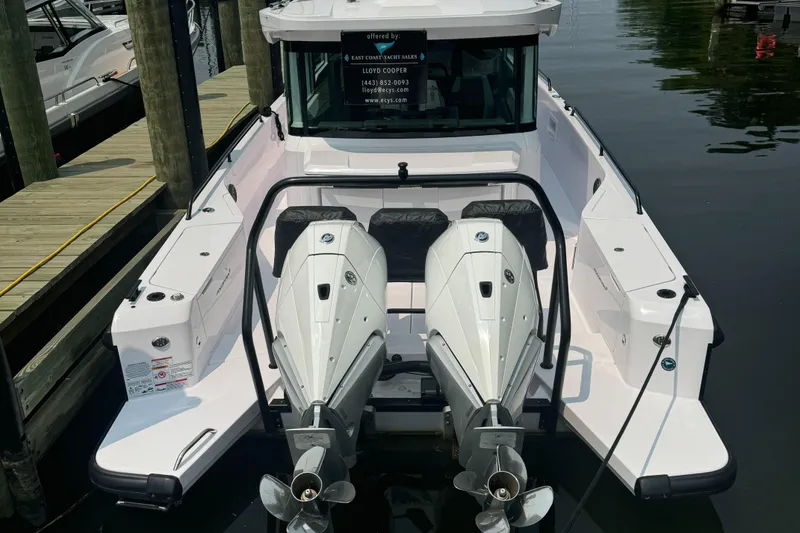 Slide: The Image of 2024 Axopar 37 Cross Cabin XC with dual outboard engines docked at a marina. - 11