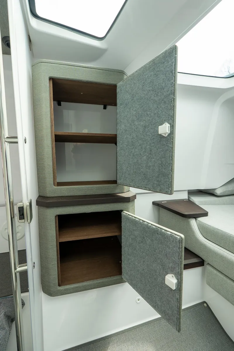 Slide: The Image of 2024 Axopar 37 Cross Cabin XC interior storage cabinets with open doors. - 21