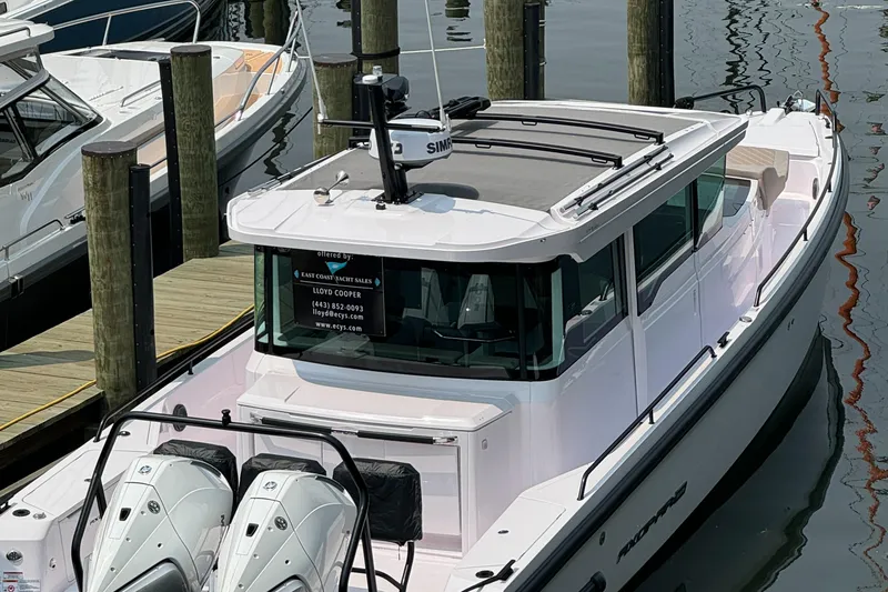 Slide: The Image of 2024 Axopar 37 Cross Cabin XC docked, featuring sleek design and dual outboard engines. - 8