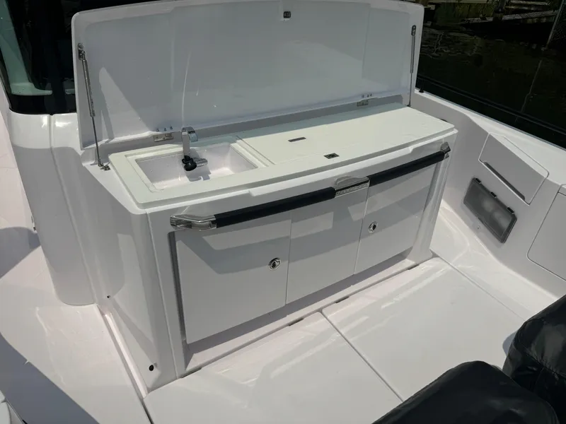 Slide: The Image of 2024 Axopar 37 Cross Cabin XC boat kitchenette with sink and storage. - 9