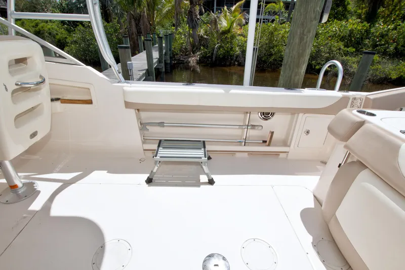Slide: The Image of 2013 Grady-White Freedom 275 boat interior with seating and storage, dockside view. - 11