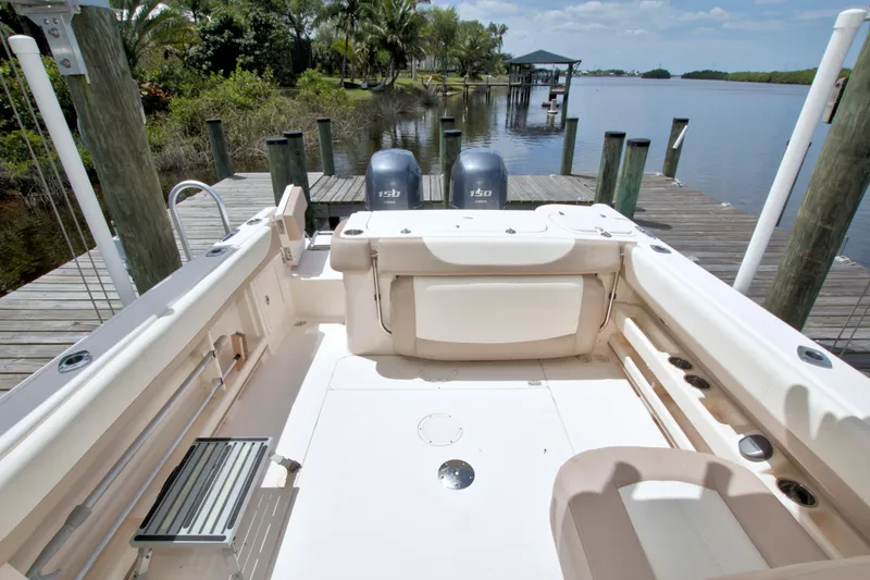 Slide: The Image of 2013 Grady-White Freedom 275 boat interior at dock, featuring dual engines and spacious seating. - 13