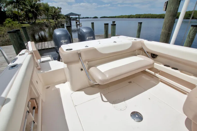 Slide: The Image of 2013 Grady-White Freedom 275 boat interior with dual Yamaha 150 engines at a dock. - 17