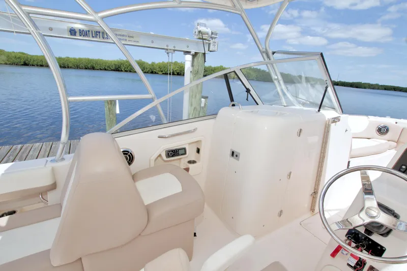 Slide: The Image of 2013 Grady-White Freedom 275 boat interior with helm, seating, and water view. - 19