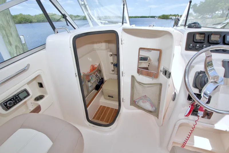 Slide: The Image of 2013 Grady-White Freedom 275 boat interior with storage compartment and steering wheel. - 20
