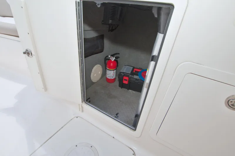 Slide: The Image of Storage compartment on a 2013 Grady-White Freedom 275 boat with fire extinguisher and toolbox. - 25
