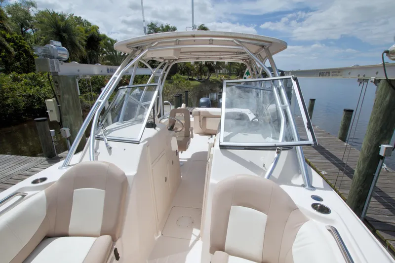 Slide: The Image of 2013 Grady-White Freedom 275 boat docked, featuring open cockpit and seating area. - 33