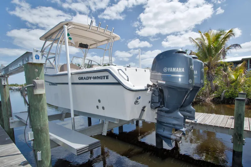 Slide: The Image of 2013 Grady-White Freedom 275 boat with Yamaha engines on a lift by the dock. - 40
