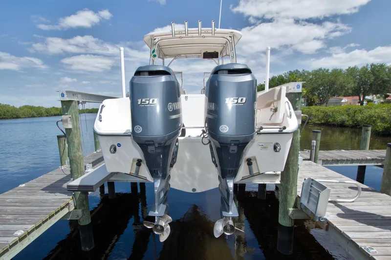 Slide: The Image of 2013 Grady-White Freedom 275 boat with twin Yamaha 150 engines docked by a serene lake. - 41