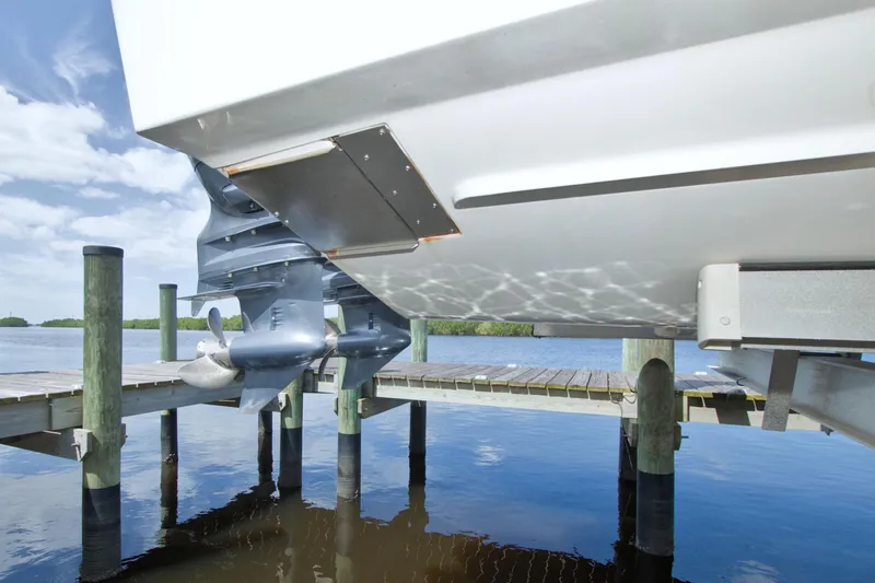 Slide: The Image of 2013 Grady-White Freedom 275 boat docked, showing dual outboard motors and calm water reflection. - 43