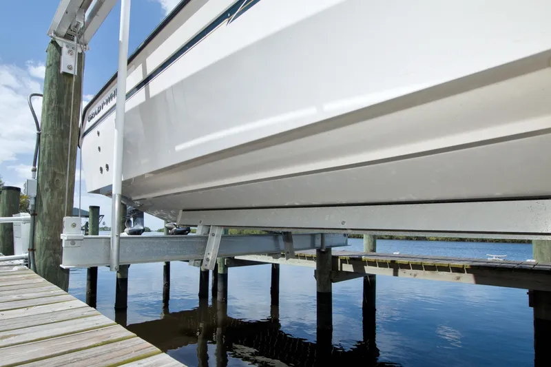 Slide: The Image of 2013 Grady-White Freedom 275 boat on lift at dockside, clear sky background. - 44