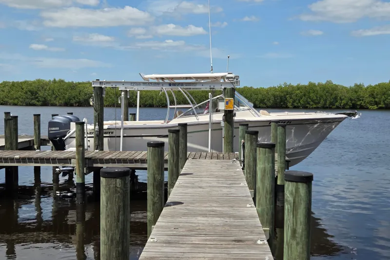 Slide: The Image of 2013 Grady-White Freedom 275 boat docked on a sunny day by the water. - 45