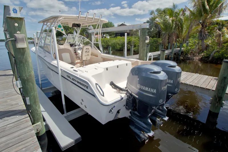 Slide: The Image of 2013 Grady-White Freedom 275 boat docked, featuring dual Yamaha 150 engines. - 5