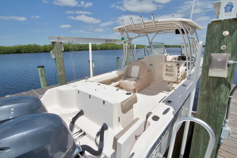 Slide: The Image of 2013 Grady-White Freedom 275 boat docked by a serene waterfront under a clear sky. - 9