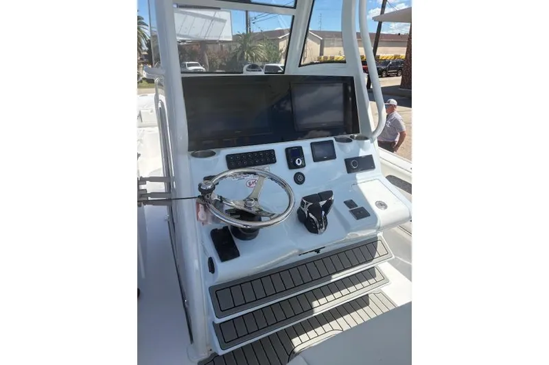 Slide: The Image of Helm of 2026 Tidewater 3100 Carolina Bay boat with modern controls and displays. - 2