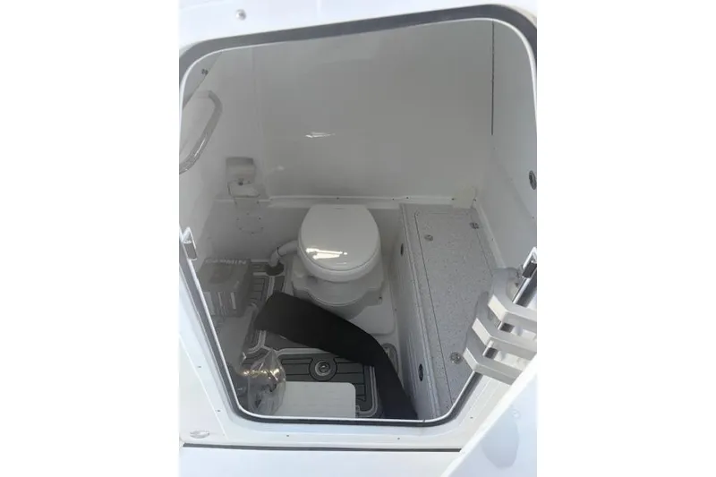 Slide: The Image of Interior of 2026 Tidewater 3100 Carolina Bay boat featuring a compact marine toilet. - 8