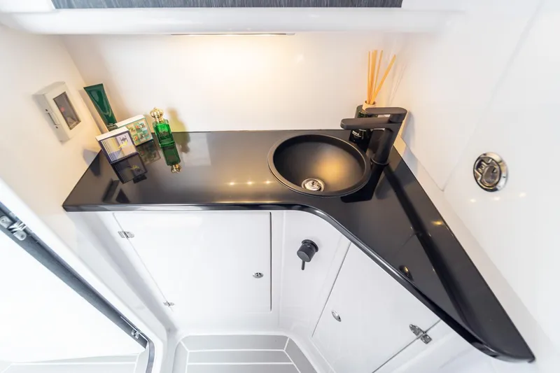 Slide: The Image of Luxurious bathroom sink area in 2025 Cigarette 42' Auroris boat, featuring sleek black countertop. - 12