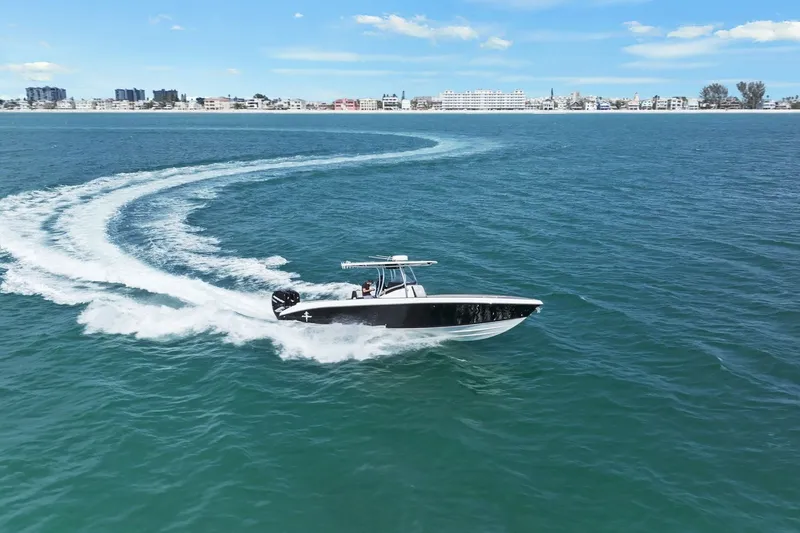 Slide: The Image of Statement 350 Open boat 2012 on open sea, city in background. - 3
