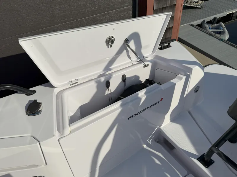 Slide: The Image of 2024 Axopar Cross Cabin storage compartment with open lid, showcasing sleek design and functionality. - 18