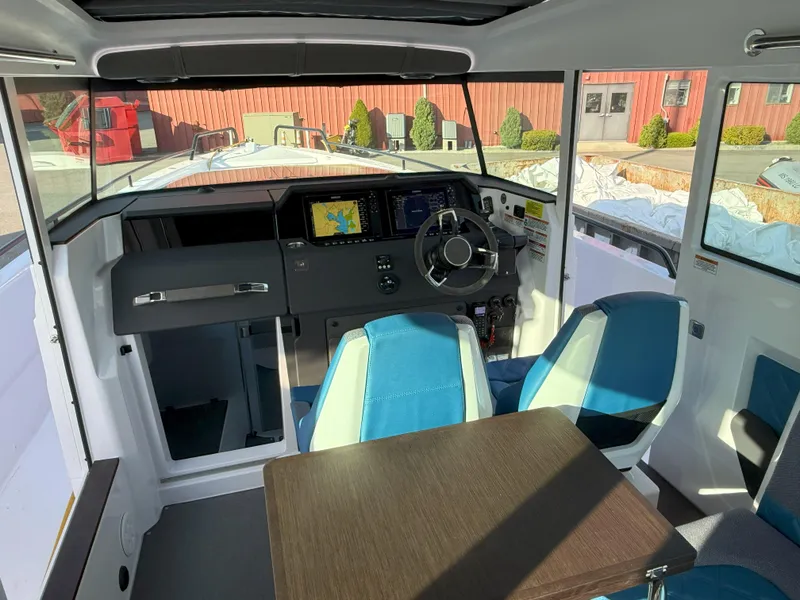 Slide: The Image of 2024 Axopar Cross Cabin interior with modern dashboard, steering wheel, and blue seating. - 29