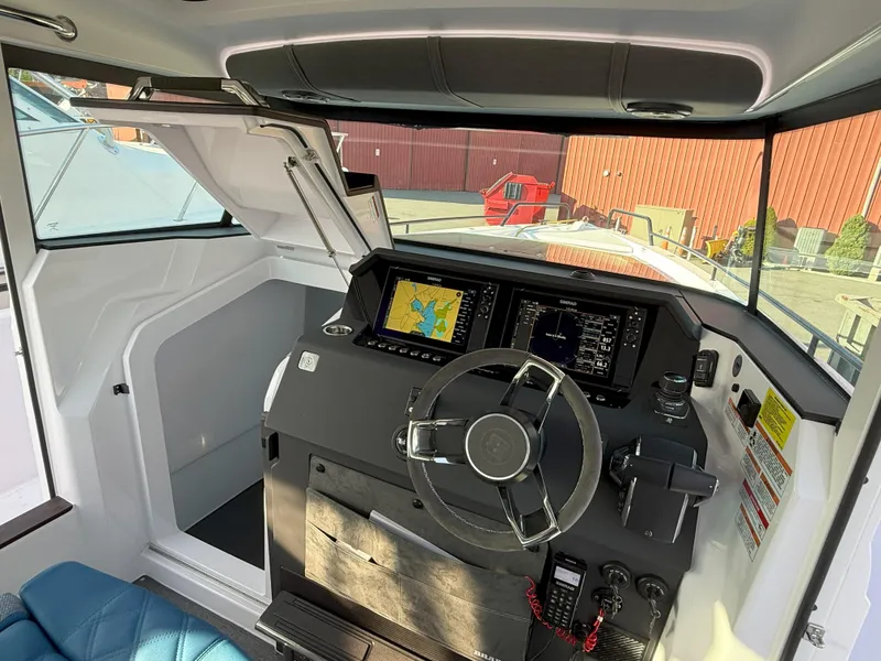 Slide: The Image of 2024 Axopar Cross Cabin boat interior with modern navigation system and steering wheel. - 33