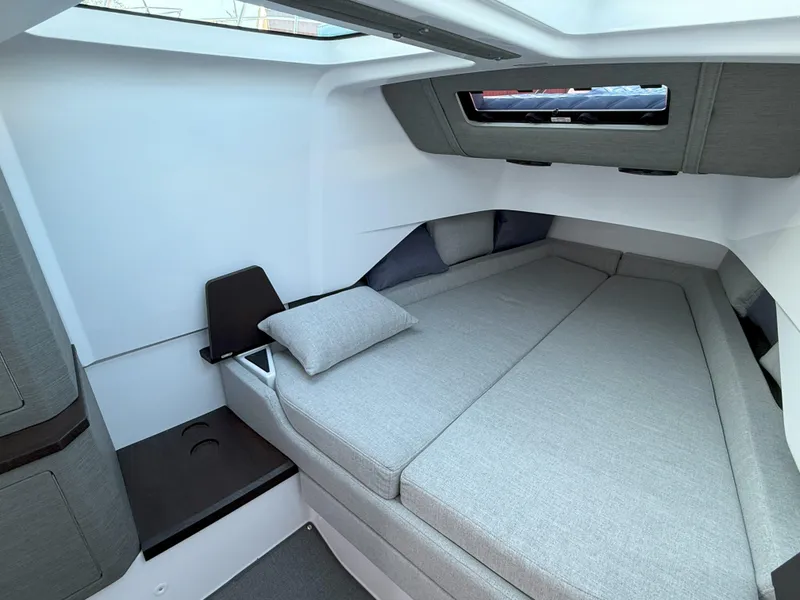 Slide: The Image of 2024 Axopar Cross Cabin interior with modern gray bedding and sleek design. - 46