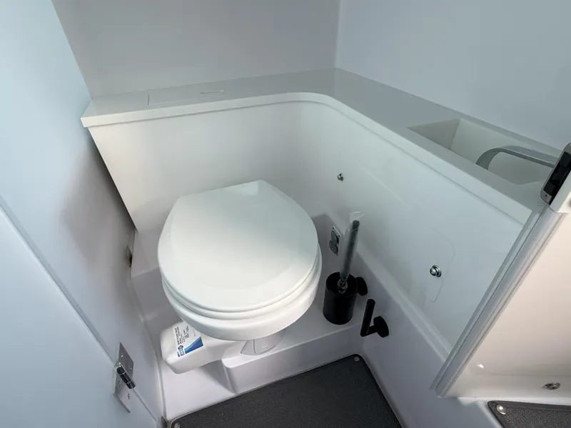 Slide: The Image of 2024 Axopar Cross Cabin bathroom interior with modern white toilet and sleek design. - 53