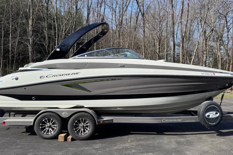 The Image of 2022 Crownline 265 SS boat on trailer, parked in wooded area. - 0