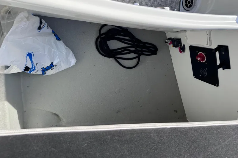 Slide: The Image of Storage compartment of 2022 Crownline 265 SS boat with rope and plastic bag. - 21