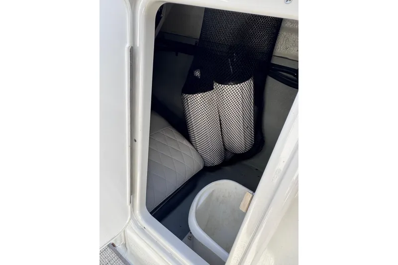 Slide: The Image of Interior storage compartment of 2022 Crownline 265 SS boat with netted storage and seating. - 26