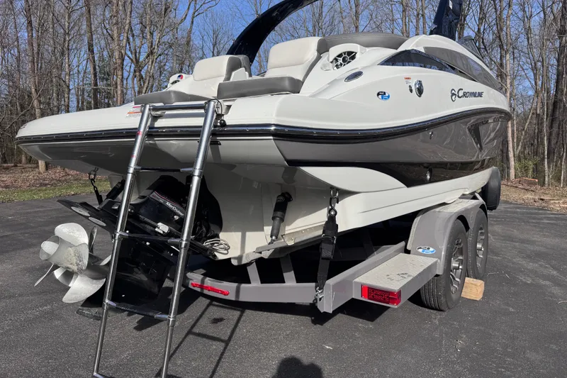 Slide: The Image of 2022 Crownline 265 SS boat on trailer, rear view with ladder, parked outdoors. - 3
