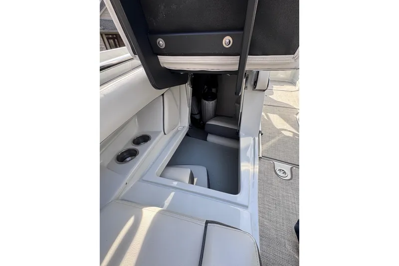 Slide: The Image of 2022 Crownline 265 SS boat interior with storage compartment and cup holders. - 33
