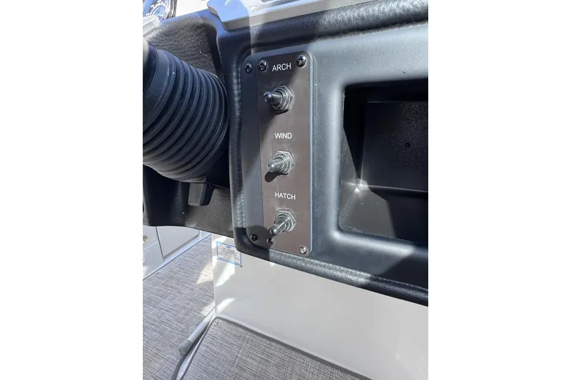 Slide: The Image of Control panel on 2022 Crownline 265 SS boat with switches for arch, wind, and hatch. - 42