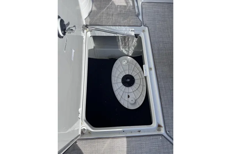 Slide: The Image of Storage compartment in 2022 Crownline 265 SS boat, featuring a circular hatch cover. - 47
