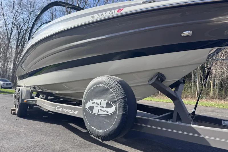 Slide: The Image of 2022 Crownline 265 SS boat on trailer, parked outdoors on a sunny day. - 5