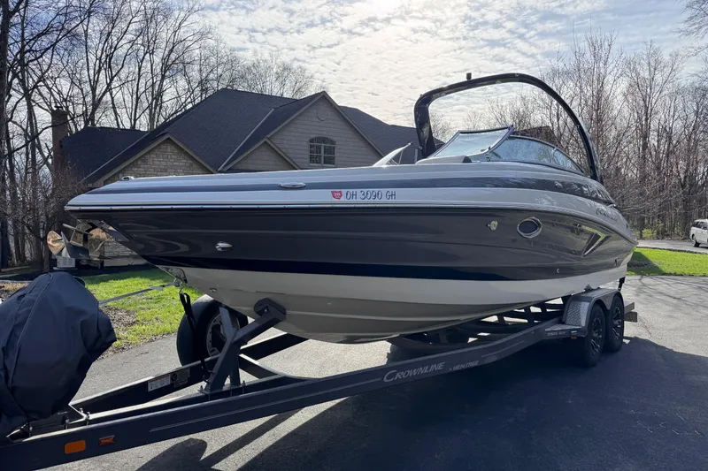 Slide: The Image of 2022 Crownline 265 SS boat on trailer, parked in residential driveway. - 6