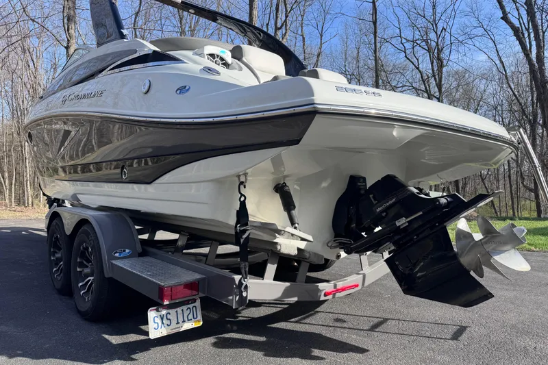 Slide: The Image of 2022 Crownline 265 SS boat on trailer in wooded area. - 8