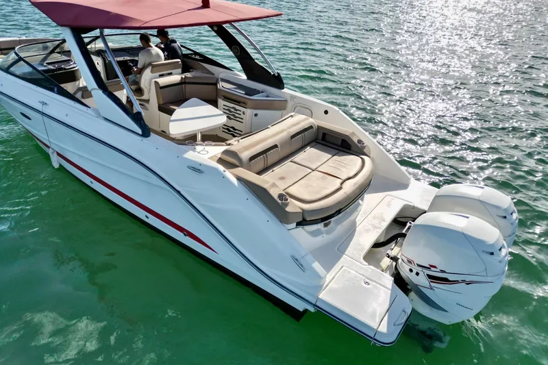 Slide: The Image of 2017 Sea Ray SLX 310 Outboard cruising on clear water, featuring spacious seating and dual engines. - 10