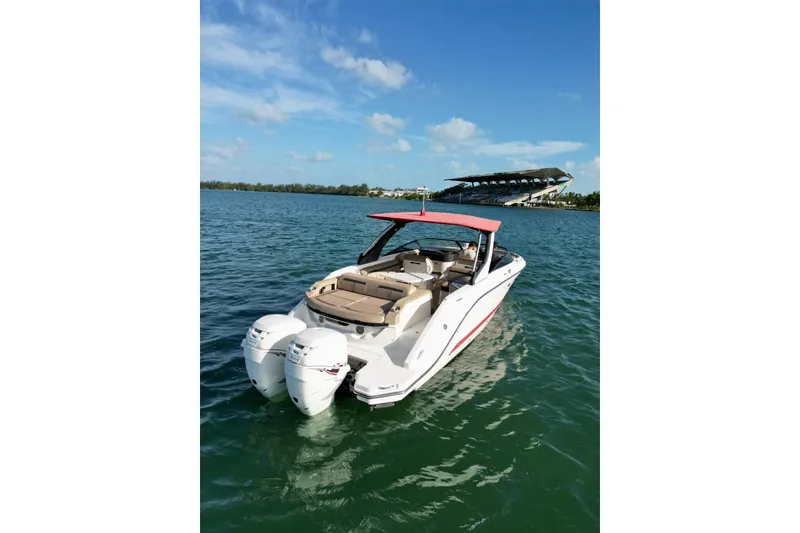 Slide: The Image of 2017 Sea Ray SLX 310 Outboard boat on calm water under a clear blue sky. - 11