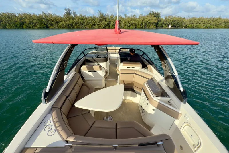 Slide: The Image of 2017 Sea Ray SLX 310 Outboard boat with red canopy on calm water. - 12