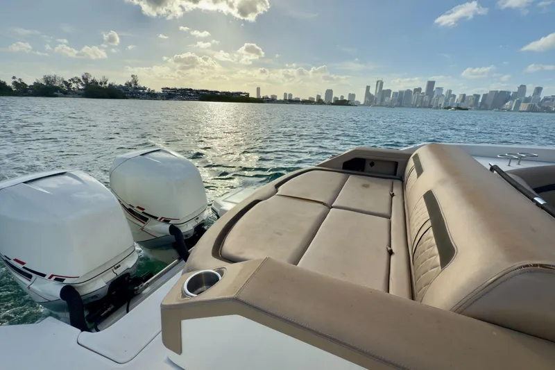 Slide: The Image of 2017 Sea Ray SLX 310 Outboard boat with twin engines, overlooking a city skyline on the water. - 19