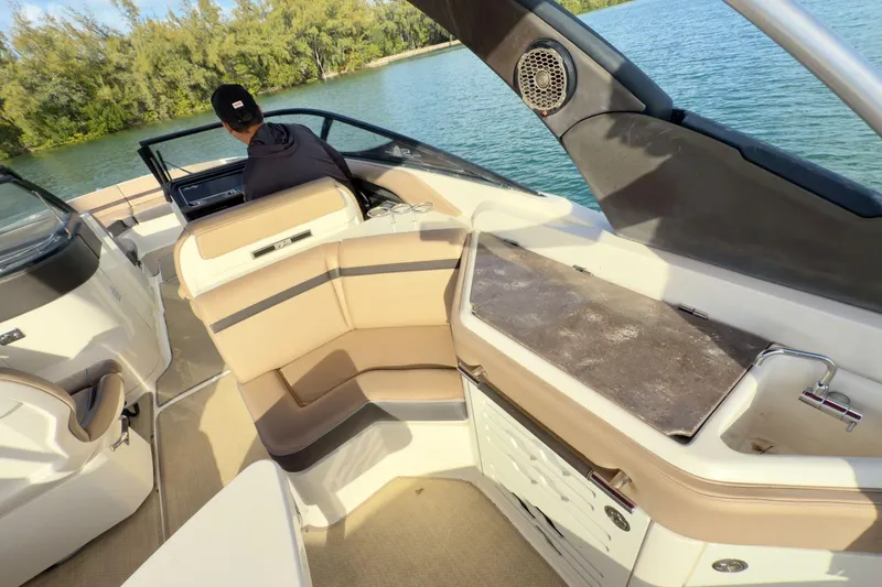 Slide: The Image of 2017 Sea Ray SLX 310 Outboard interior with seating and helm, set on a scenic waterway. - 20