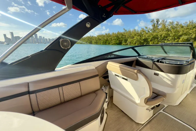 Slide: The Image of 2017 Sea Ray SLX 310 Outboard interior with city skyline and water view. - 30