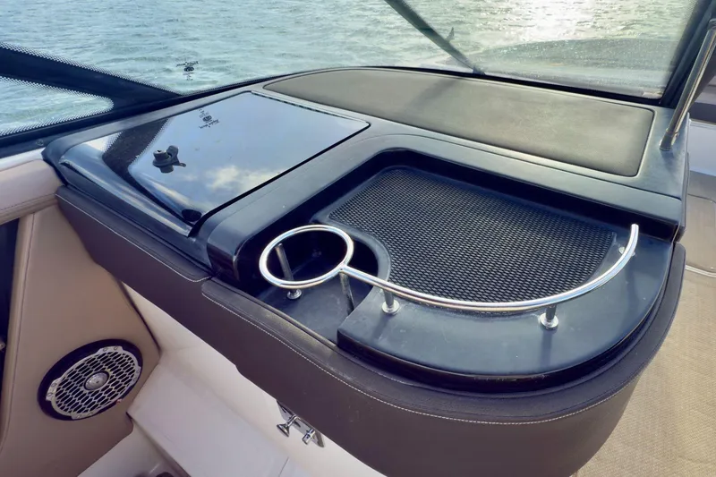 Slide: The Image of 2017 Sea Ray SLX 310 Outboard boat interior with cup holder and storage area. - 32