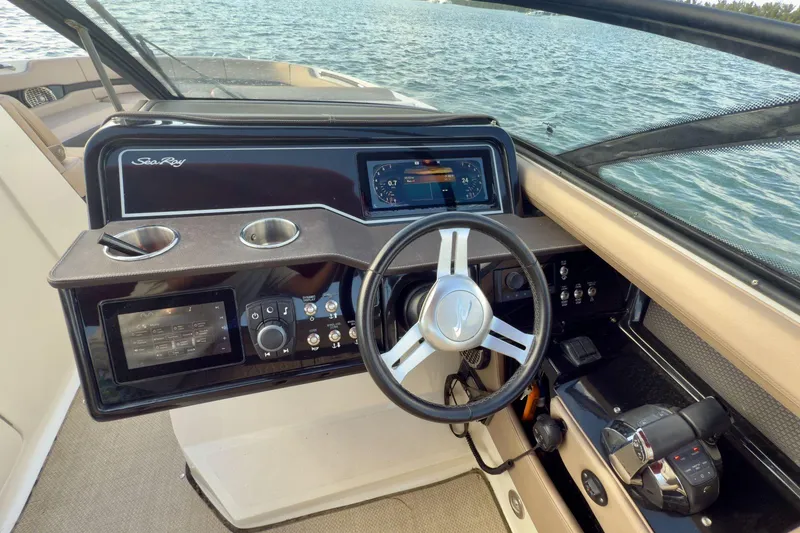 Slide: The Image of 2017 Sea Ray SLX 310 Outboard helm with steering wheel and control panel on water. - 35