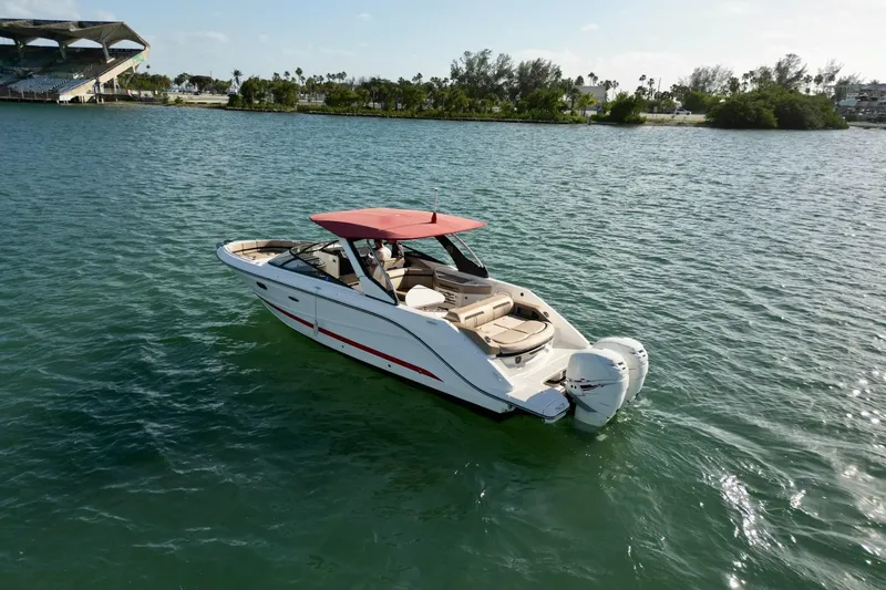 Slide: The Image of 2017 Sea Ray SLX 310 Outboard boat with red canopy on calm water. - 4