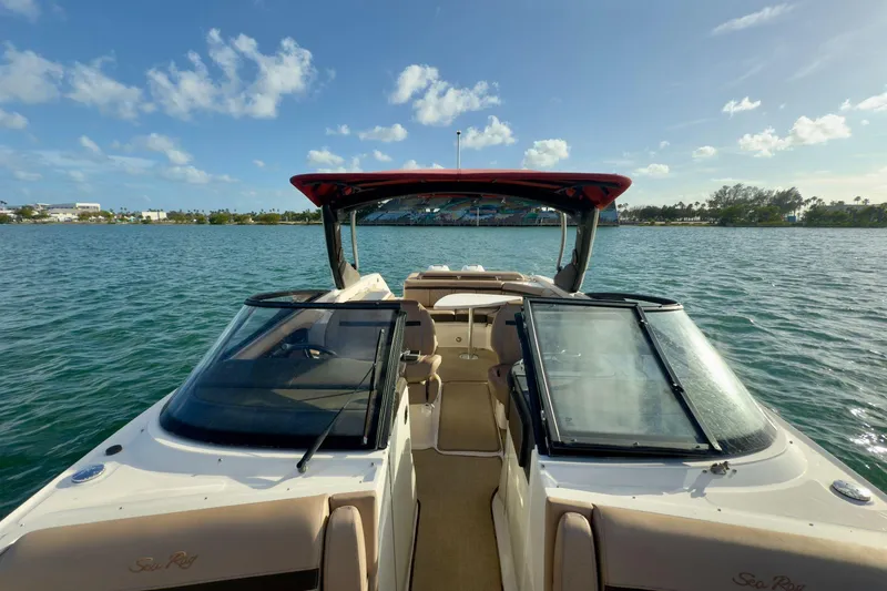 Slide: The Image of 2017 Sea Ray SLX 310 Outboard boat on calm water under a clear blue sky. - 44
