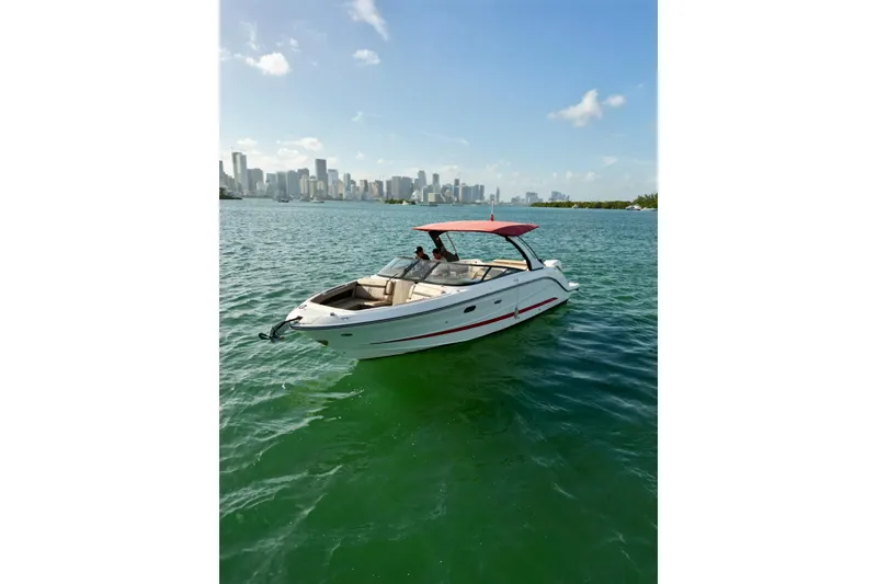 Slide: The Image of 2017 Sea Ray SLX 310 Outboard boat cruising near city skyline on sunny day. - 6