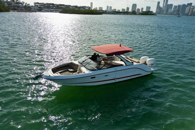 Slide: The Image of 2017 Sea Ray SLX 310 Outboard cruising on sunny waters near a city skyline. - 7